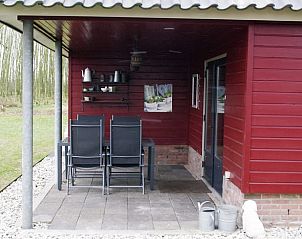 Knusse zitplek op overdekt terras van Huisje in Escharen, Noord Brabant.
