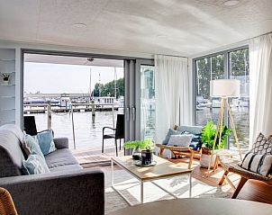 Binnenruimte van Vakantiehuis in Dinteloord met veel lichtinval en uitzicht op de natuur.