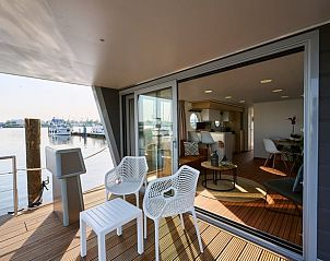Terras van Vakantiehuis in Dinteloord met comfortabele zitplaatsen en uitzicht op de haven.