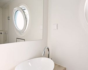 Moderne badkamer met ronde spiegel in Vakantiehuis in Dinteloord, West Brabant.