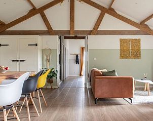 Gezellige woonkamer in Vakantiehuisje in Rucphen, West Brabant met houten balken en moderne inrichting.