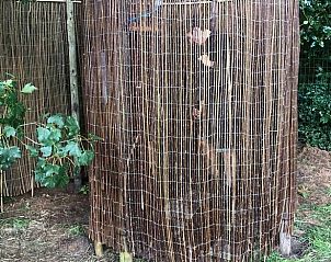 Buitendouche met bamboe omheining bij Vakantiehuis in Rucphen, ideaal voor natuurliefhebbers in West Brabant.