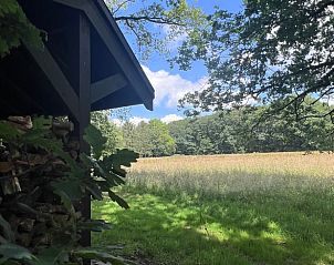 Houten schuur met uitzicht op het veld bij Vakantiehuis in Rucphen, perfect voor natuurliefhebbers in West Brabant.