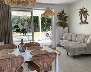 Stijlvolle woonkamer in Villa Wellness Retreat, een vakantiehuis in Halderberge, Noord Brabant, met uitzicht op de groene natuur vanaf het terras.