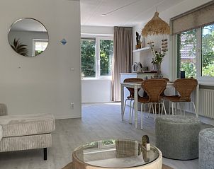 Gezellige woonkamer van Villa Wellness Retreat in Halderberge, Noord Brabant. Geniet van het licht en de serene sfeer in dit vakantiehuis.