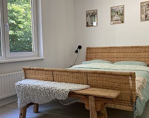 Gezellige slaapkamer in Villa Wellness Retreat, een vakantiehuis in Halderberge, West Brabant, met uitzicht op de groene natuur.