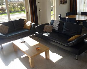 Lichte woonkamer in Duinvilla Noor, Julianadorp aan Zee, met ruime zithoek en uitzicht op de tuin.