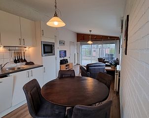 Moderne keuken in De Blenck 21, vakantiehuis in Callantsoog, met eetgedeelte en uitzicht op de tuin.