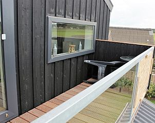 Gezellig balkon van Hooizolder vakantieverblijf in Camperduin, met uitzicht op de natuur.