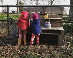 Kinderen spelen in de tuin van Huisje in Hem, gezinsvriendelijk vakantiehuis in Noord-Holland.