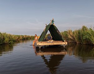 Varen door de kanalen bij Huisje in Katwoude, een serene bootaccommodatie aan de IJsselmeerkust, Noord-Holland.