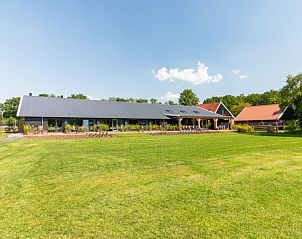 Buitenzijde van De Manderhoeve vakantiehuis in Mander, Twente, omgeven door groen en landelijke rust.