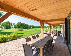 Ruime veranda met uitzicht op de natuur bij De Manderhoeve vakantiehuis in Mander, Twente, perfect voor buitenmaaltijden.