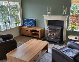 Gezellige woonkamer van Hosta vakantiehuis in Ootmarsum, Twente met open haard en TV.