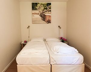 Comfortabele slaapkamer in Hoeve Springendal vakantiehuis, Ootmarsum, met kunstwerk.