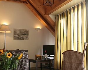 Ruime woonkamer met houten balken in Hoeve Springendal appartement, Ootmarsum.