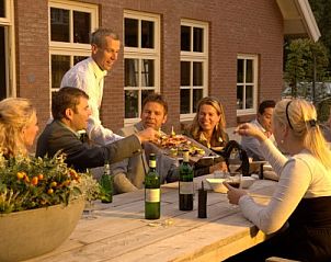 Gezellige avond op het terras van Landgoed Nieuwhuis vakantiehuis in Ootmarsum, Twente, genieten van een maaltijd.