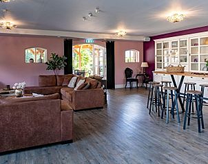 Ruime woonkamer in Landgoed Nieuwhuis vakantiehuis in Ootmarsum, Twente, met comfortabele banken en bar.