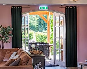 Open deuren naar terras vanuit woonkamer in Landgoed Nieuwhuis vakantiehuis in Ootmarsum, Twente.