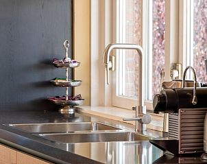 Keuken met moderne apparatuur in Landgoed Nieuwhuis vakantiehuis in Ootmarsum, Twente, met uitzicht op de tuin.