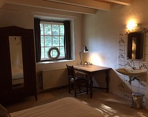 Gezellige slaapkamer in VakantiehuisVasse.nl, een vakantiehuis in Vasse, Twente, met rustiek bureau en uitzicht op de groene natuur.