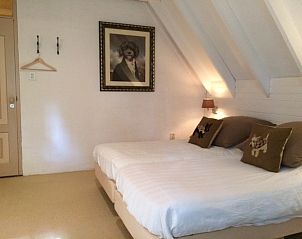 Gezellige slaapkamer in VakantiehuisVasse.nl, Twente, met comfortabele bedden en rustieke inrichting voor een ontspannen verblijf in Overijssel.