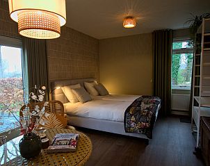 Gedetailleerd wandkleed in Vakantiehuis in Oldenzaal, Twente, voegt een artistieke touch toe aan de slaapkamer.