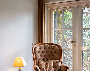 Knusse leeshoek in Huisje in Oldenzaal vakantiehuis in Twente met uitzicht op de tuin in Overijssel.