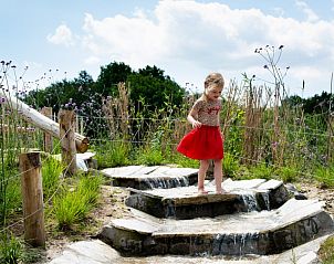 Kind speelt in natuurlijke waterpartij bij vakantiehuis Zeldam, Enter, Twente.