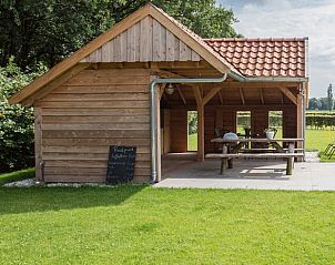 Overdekt terras bij Notterveld bed and breakfast, Notter, Twente, met uitzicht op de omliggende natuur en groene velden.