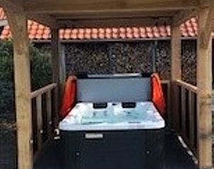 Overdekte jacuzzi in Vakantiehuisje in Boekelo, Twente, biedt luxe ontspanning in de buitenlucht.