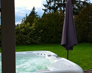 Bubbelende jacuzzi in de tuin van Vakantiehuis in Lonneker, Twente, biedt ontspanning in de natuur van Overijssel.