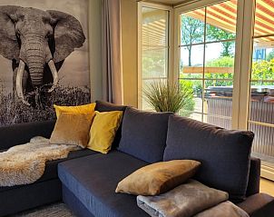 Comfortabele zithoek in Vakantiehuis in Lonneker, Twente, met uitzicht op het terras en de natuur van Overijssel.