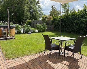 Terras bij Vakantiehuisje in Dedemsvaart, een ontspannende vakantiewoning in Vechtstreek, Overijssel met tuinzicht.