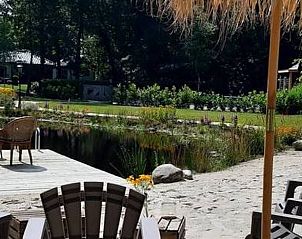Relaxplek met strandstoelen en parasols bij Vakantiehuisje in De Bult, Overijssel.