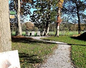 Zonnig wandelpad door groene tuin bij Vakantiehuisje in De Bult, Noordwest Overijssel.