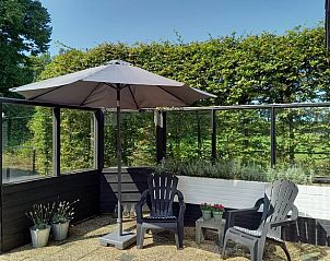 Vakantiehuis in Baars, knus terras met zitje en parasol, ideaal voor ontspanning in Overijssel.