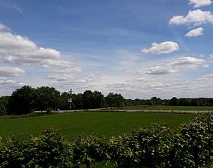 Vakantiehuis in Baars, weids uitzicht over groene weilanden en blauwe luchten in Overijssel.
