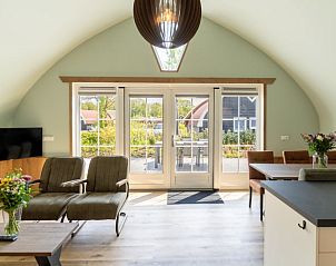 Lichte woonkamer in Vakantiehuis in Baars met uitzicht op het terras, gelegen in Overijssel.