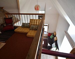 Knusse loft in Vakantiehuisje in Zalk met comfortabele zitkussens en uitzicht op de woonkamer.