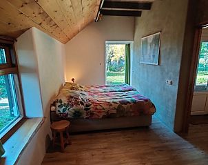 Gezellige slaapkamer in Vakantiehuisje in Zalk met houten plafond en tuinzicht.