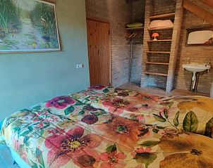 Tweepersoonskamer met bloemenprints en gezellige sfeer in Vakantiehuisje in Zalk, Noordwest Overijssel.