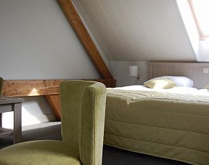 Sfeervolle slaapkamer in Huisje in Vreeland, vakantieaccommodatie in Vreeland, Utrecht met ruim tweepersoonsbed en dakraam.