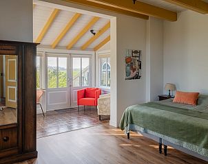 Lichte slaapkamer in Vakantiehuis in Nigtevecht, Utrecht met uitzicht op groene omgeving.