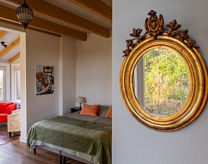 Elegant interieur in Vakantiehuis in Nigtevecht, Utrecht met decoratieve spiegel en uitzicht op natuur.