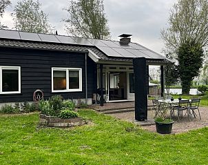 Terras van Vakantiehuis in Nigtevecht, Utrecht noord, met uitzicht op een groene tuin.
