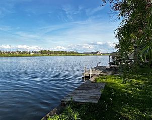 Heldere blauwe lucht boven de rivier bij Vakantiehuis in Nigtevecht, Utrecht noord, met een houten steiger.