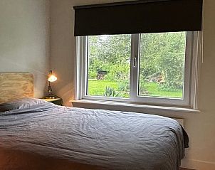 Slaapkamer in Vakantiehuis in Nigtevecht, Utrecht noord, met groot raam en uitzicht op de natuur.