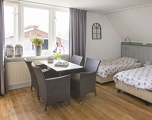 Comfortabele binnenruimte bij Boerderij De Boterbloem, Amerongen, Utrechtse Heuvelrug, met zitgedeelte en uitzicht op de boerderij.