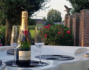 Champagne en glazen bij de jacuzzi van Arendsnest, een vakantiehuis in Renswoude, Utrechtse Heuvelrug, Utrecht.